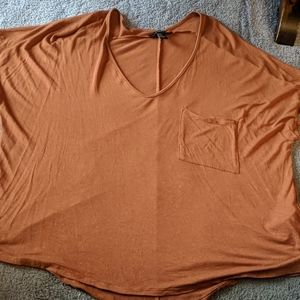 Pumpkin color scoop neck blouse with a pocket